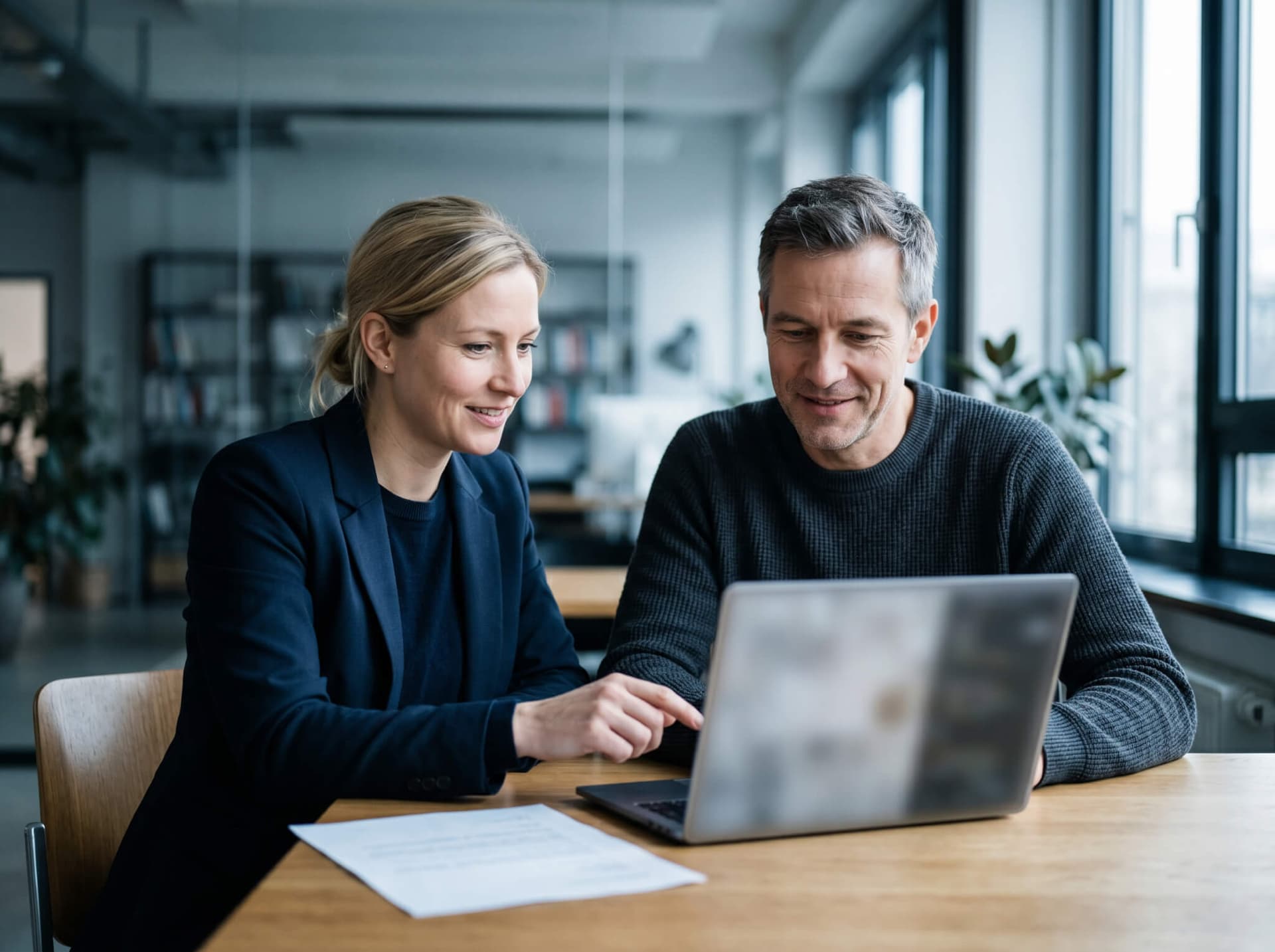 Zwei Kollegen arbeiten einvernehmlich gemeinsam am Laptop